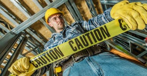 Construction Worker holding caution tape