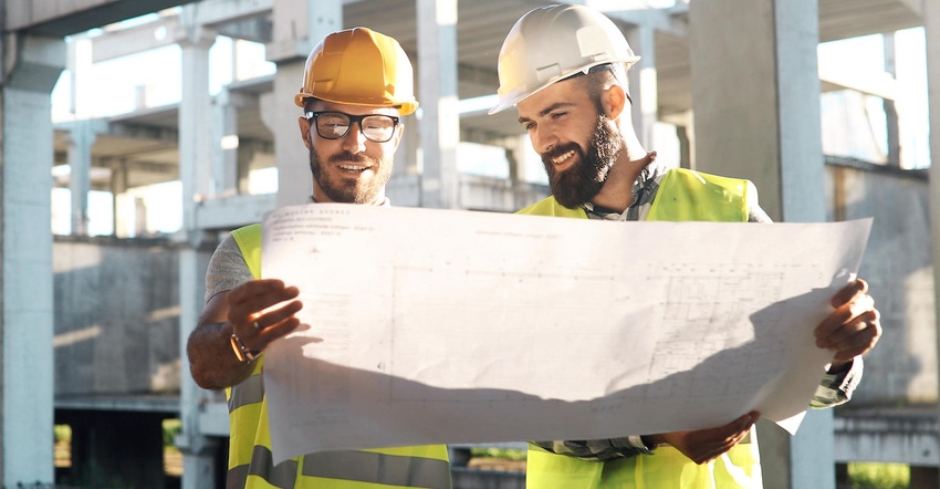 Two team members reviewing plans on a construction site
