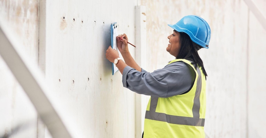 Female construction worker monitors job progress on site