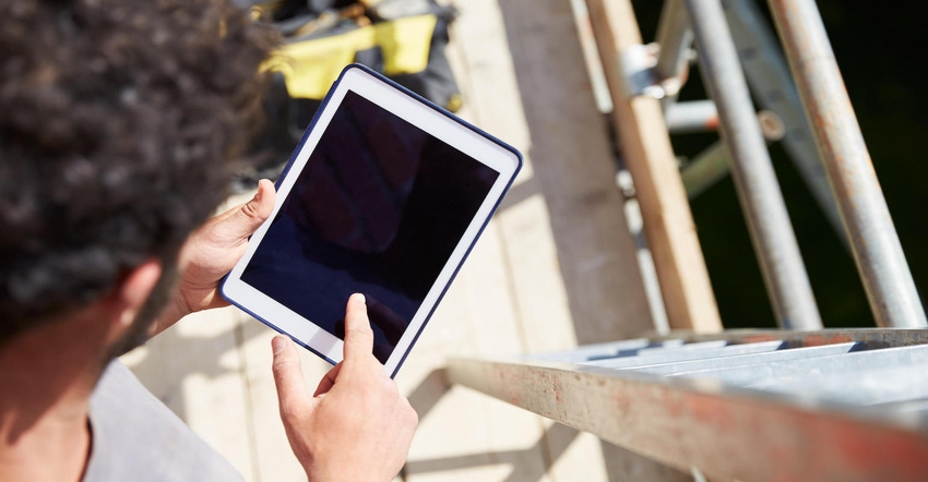 Construction worker using digital tablet on jobsite