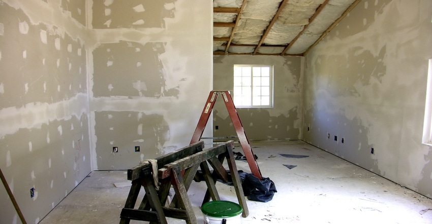 A gutted room with a ladder during a home improvement project
