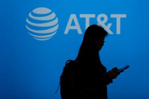 A visitor walks past US multinational telecommunications AT&T logo during the Mobile World Congress