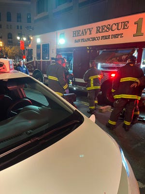 Firefighters on the scene of an accident where a woman was pinned under a self-driving taxi in San Francisco, California.