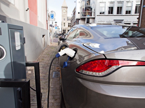 Image shows an electric car at recharging station. Image shows an electric car at recharging station.