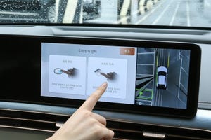A hand touching a screen inside a car showing how parking can be done automatically with just one touch with the Hyundai Mobis system