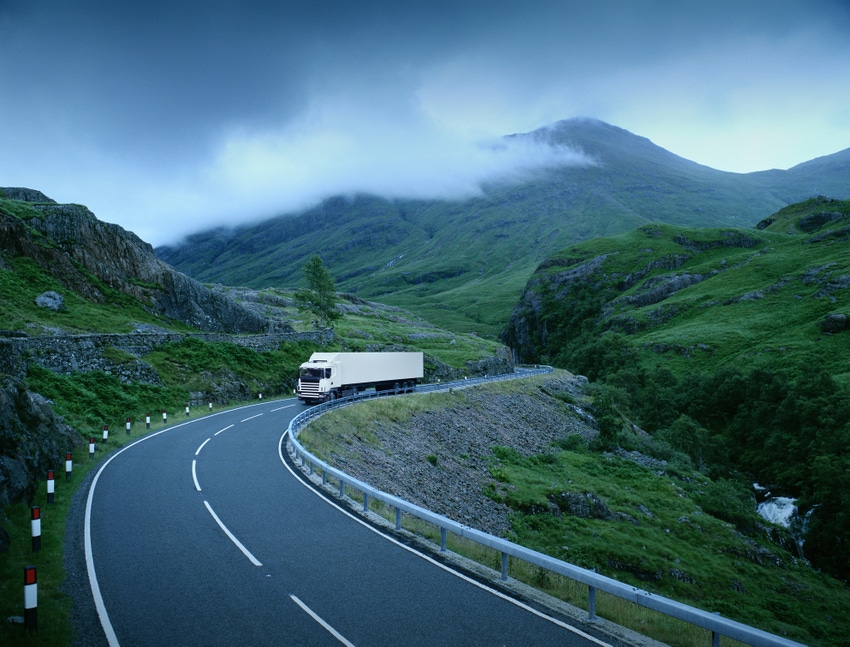 White lorry on road through rural landscape (Digital Composite)
