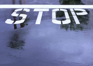 Stop-sign-written-on-wet-pavement