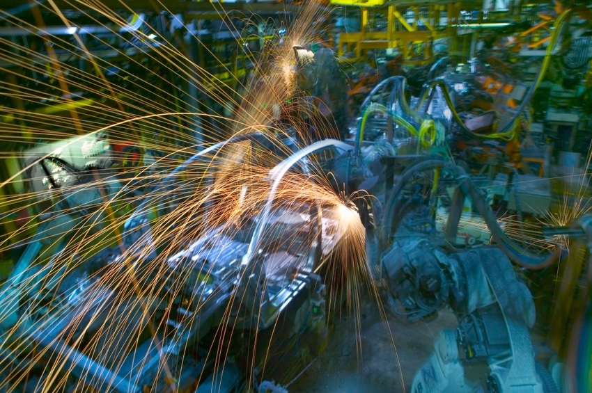 Sparks flying from robotic assembly line welding car body.
