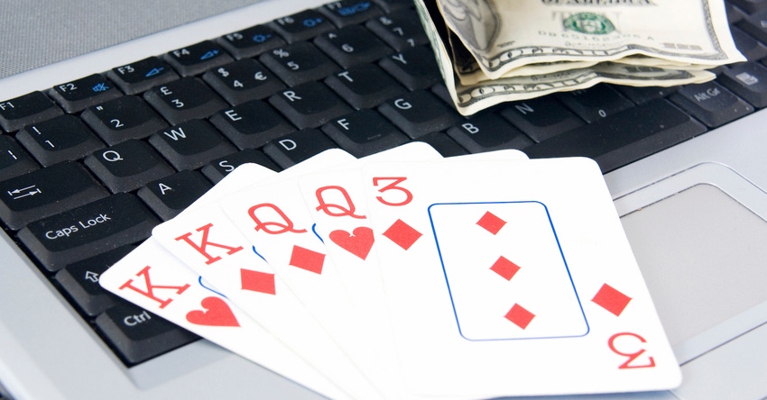 Winning card hand on computer keyboard with ten dollar bills