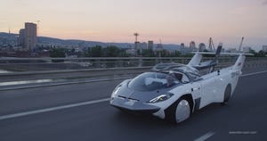KleinVision's AirCar flying car in drive mode on a highway.