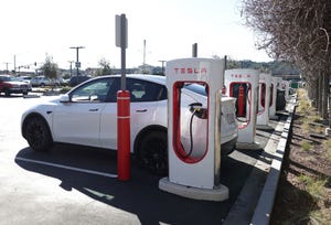 Tesla owners use charging stations in a parking lot on January 17, 2023 in Springfield, Virginia. 