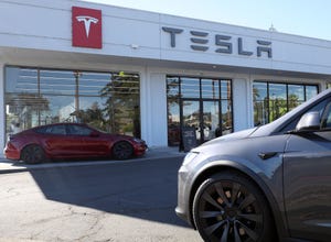 A Tesla vehicle sits outside a dealership.