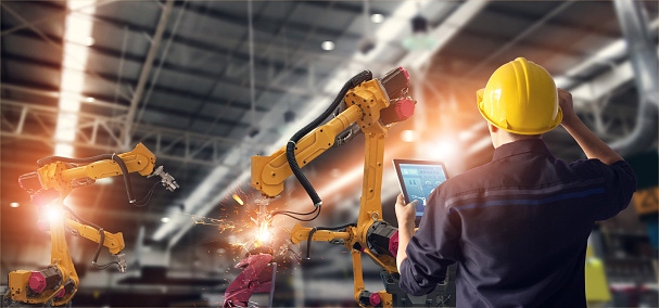 Image shows welding robotics and a digital manufacturing operation.