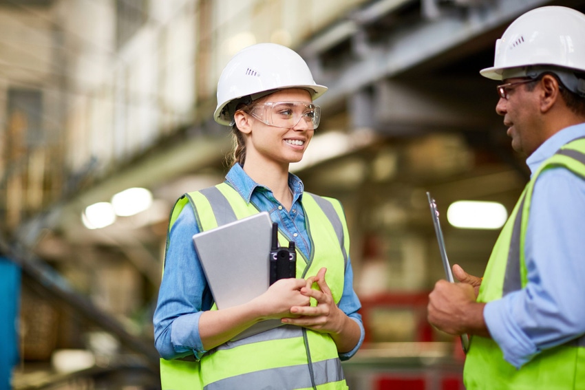 Image shows a young female apprentice training in a factory.