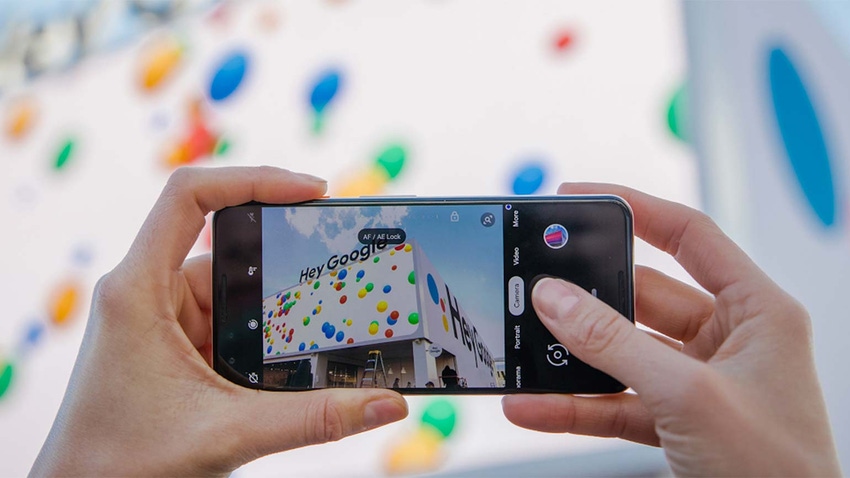 Someone taking a photo of the Google office on a smart phone