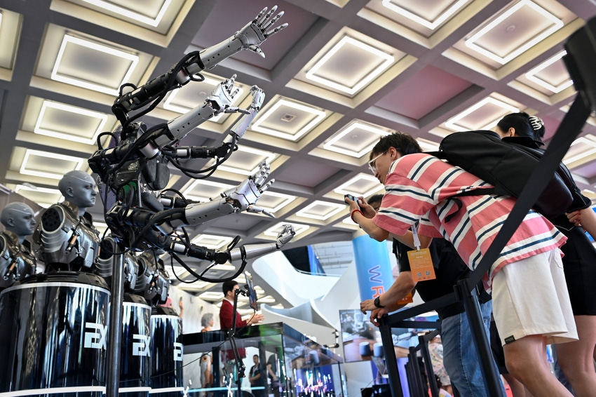 Visitors take pictures of robot arms at the 2023 World Robot Conference