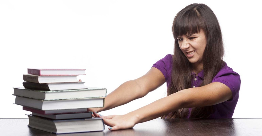 Woman pushing stack of books away