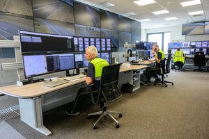 Workers watch monitors in the control center of BMW's Future Mobility Development Center 