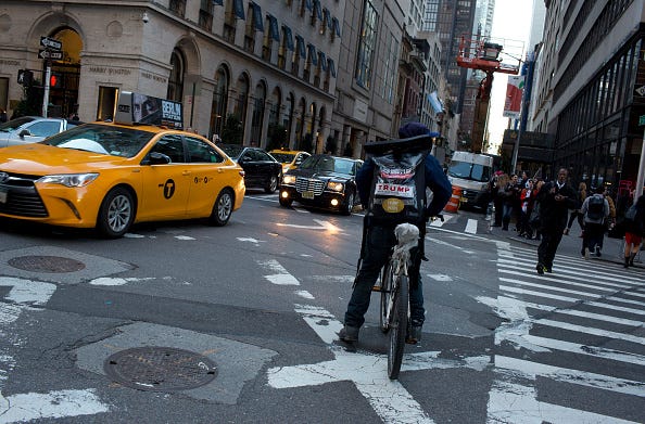 A bike messenger delivering a package in the city.