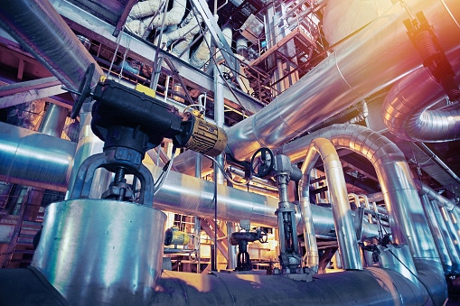 Image shows equipment, cables and piping as found inside of a industrial power plant