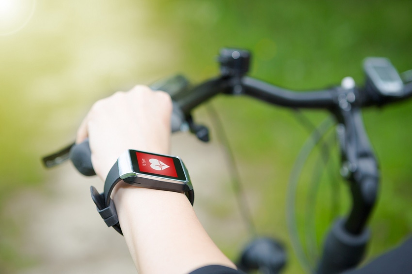 Image of woman riding bike with a smart watch heart rate monitor