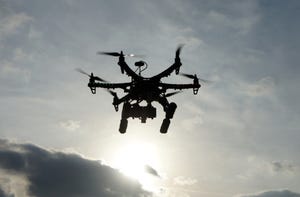Image shows a drone taking aerial photos at sunset.
