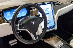 Image shows the inside of a Tesla Model X P90D full electric luxury crossover SUV car with a large touch screen