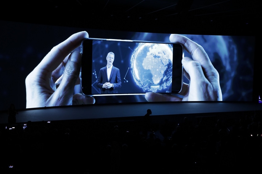 A person viewed through a mobile phone screen as part of a presentation