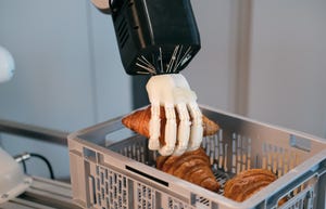 Mimic's robotic hand holding a croissant