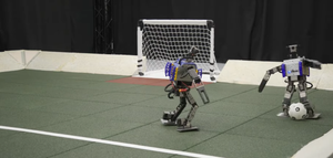 Two small-scale robots play soccer
