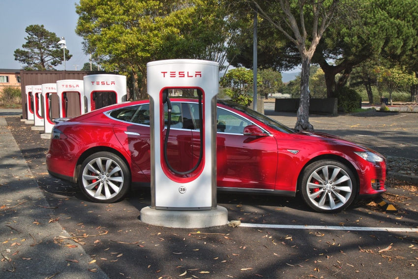 Image shows a Tesla 'S' sedan connected to 480 volt Supercharger Station.