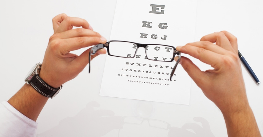 Looking through eyeglasses at an eye chart