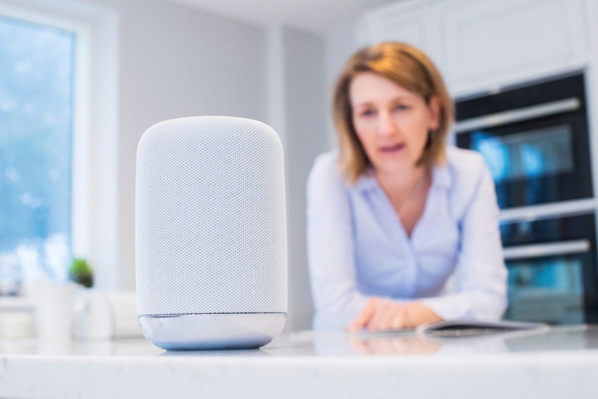 Image shows a woman In Kitchen Asking Digital Assistant Question
