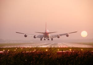 Image shows a Boeing 747 landing into sunset
