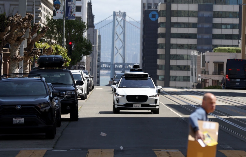 A Waymo autonomous vehicle drives along a San Francisco street.