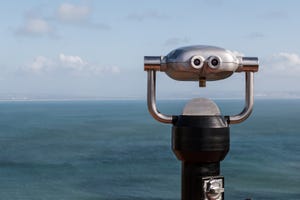 Sightseeing binoculars overlooking the ocean from a high vantage point
