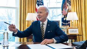 President Joe Biden at his desk signing an order