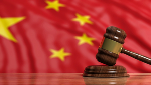 A court gavel in front of a Chinese flag