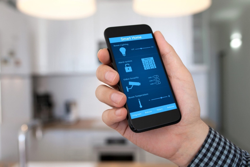 Image of man holding smartphone in a house Image of man holding smartphone in a house
