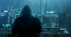 Image shows a hooded hacker breaking into data servers.