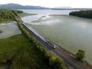 Image shows a passenger train traveling up the hudson river