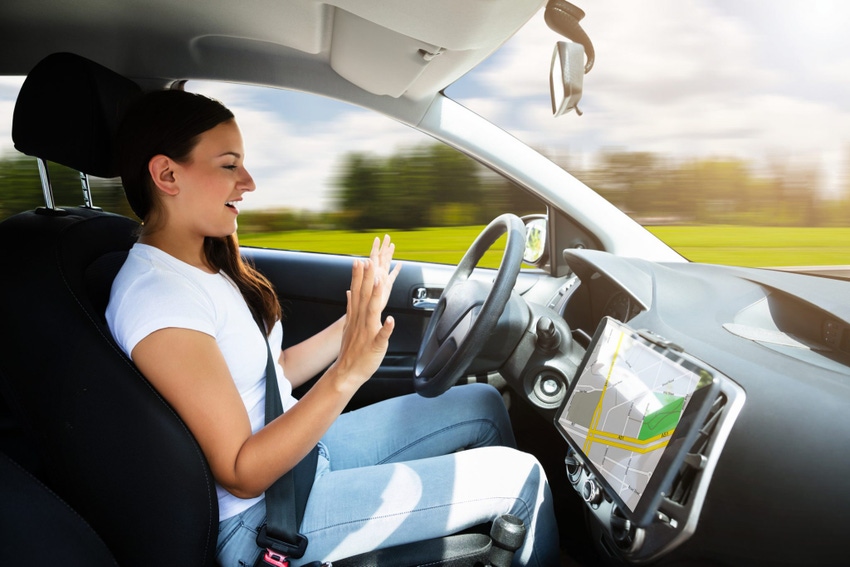 Image shows a woman sitting in a self-driving car.