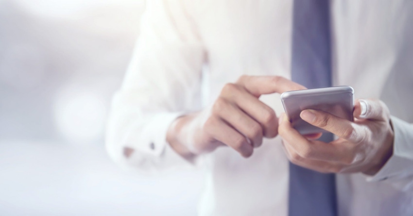 Image shows a man in a tie using a mobile phone Image shows a man in a tie using a mobile phone