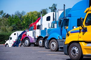 Image shows a fleet of semi trucks parked together.