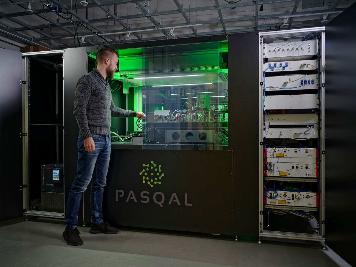 A person stands next to a Pasqal quantum computer A person stands next to a Pasqal quantum computer