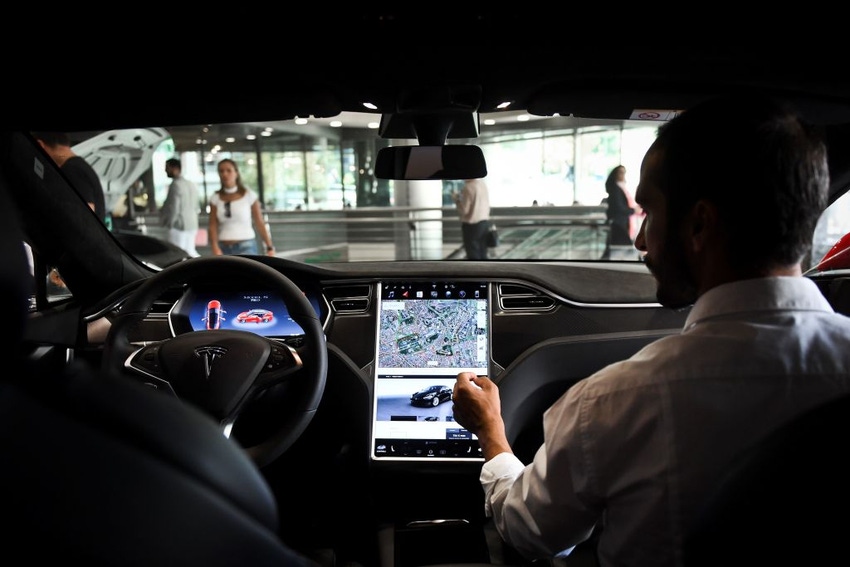 A seller shows the dashboard of the Tesla Model S car at the electric carmaker Tesla showroom .