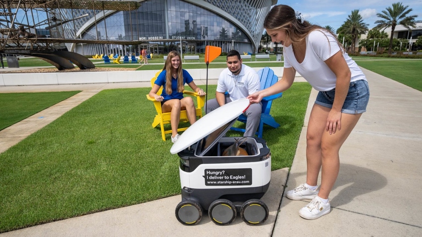 Image shows students model the Sodexo Dining Services Starship Robots, at the Daytona Beach campus