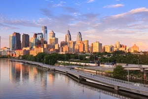 Image shows the Philadelphia skyline with the Schuylkill River.