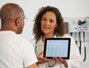 Doctor showing patient test results on digital tablet.