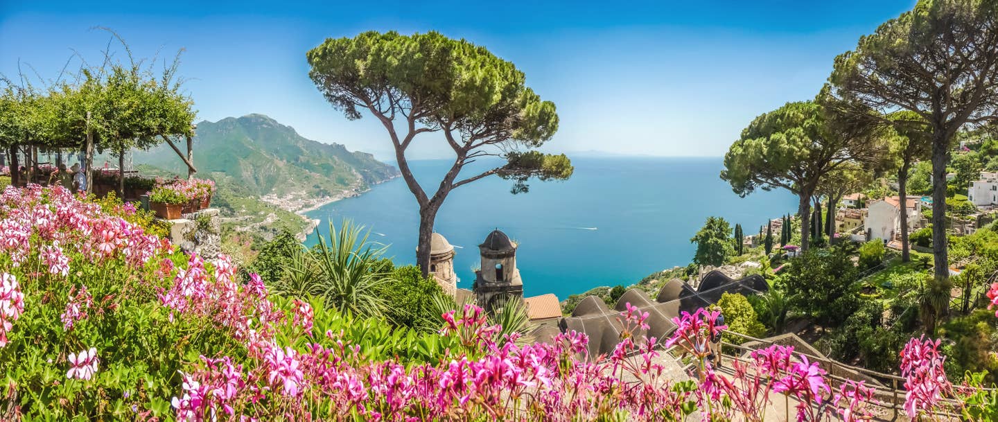 Blick aufs Meer zwischen Bäumen, Italien